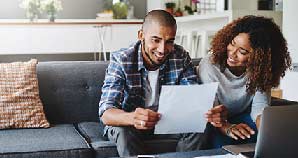 Couple sitting in front of laptop doing their banking.