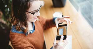 Young woman depositing a check with her smart phone.